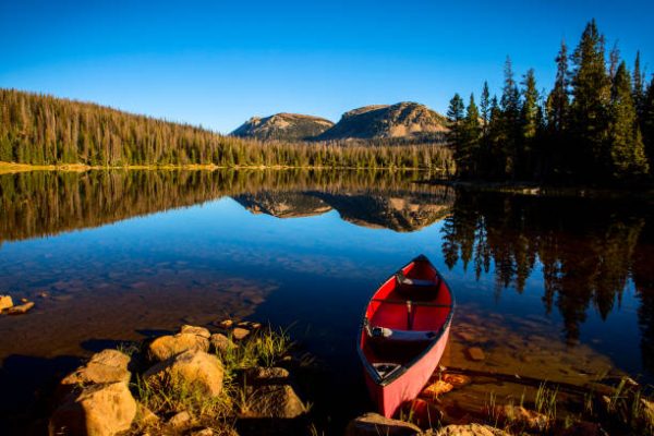 a red canoe on tranquil shoreline of a high mountain lake